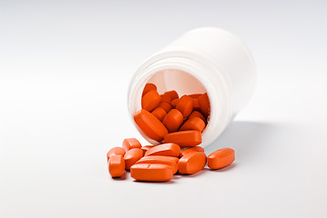Image showing orange pills spilling from bottle