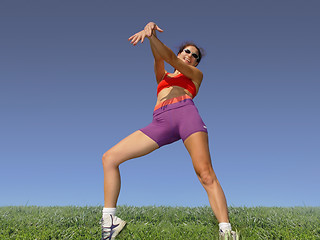 Image showing Girl exercising outdoors on the grass