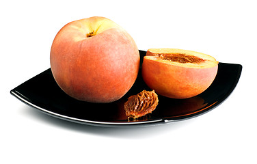 Image showing red peaches with pip on black dish