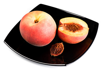 Image showing red peaches with pip on black dish