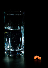 Image showing two pills and glass of water