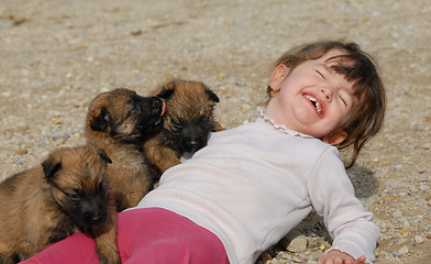 Image showing laughing girl and puppies