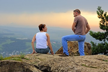 Image showing Man and woman on the top of the mountain at sunset