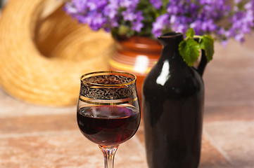 Image showing Black jug for wine and a glass of red wine 