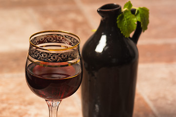 Image showing Black jug for wine and a glass of red wine 