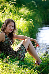 Image showing woman sitting on riverside