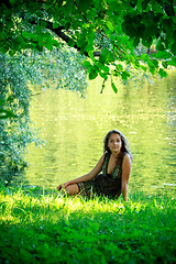 Image showing woman sitting on riverside