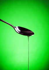 Image showing oil spill out of spoon