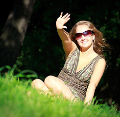 Image showing girl in sunglasses sitting in grass