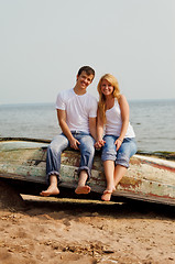 Image showing couple on a beach sitting on old boat