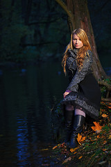 Image showing girl sitting on the edge of pond