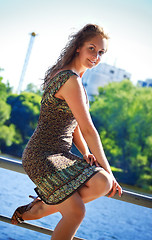 Image showing beautyful woman sitting on parapet