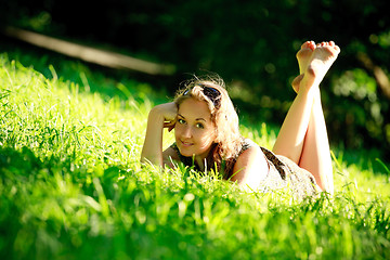Image showing beautiful girl laying on sunny meadow