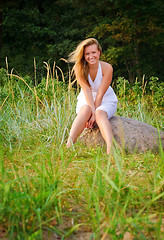 Image showing pretty woman sitting on big stone