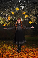 Image showing girl juggling leaves in autumn park