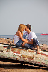 Image showing couple sitting on old boat and kiss