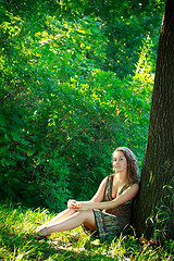 Image showing beautyful woman sitting next tree