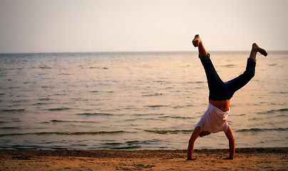 Image showing man doing handstand on beach