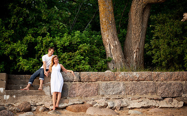 Image showing couple stand next stonewall in forest