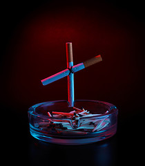 Image showing cigarette cross on ashtray