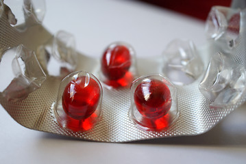 Image showing Three red pills in blister pack