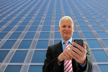 Image showing Businessman writing on his mobile phone