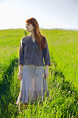 Image showing sad redhead woman in grass