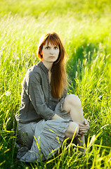 Image showing sad redhead woman in grass