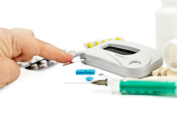Image showing Glucometer with a hand, drugs and a syringe