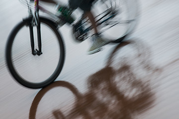 Image showing Boy on bicycle reflecting in puddle