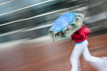 Image showing Female running with umbrella