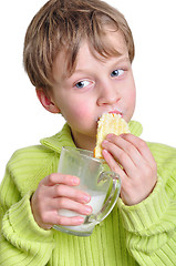 Image showing child eating cake and dringking milk