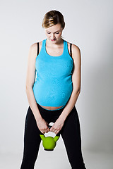 Image showing Pregnant woman exercising with kettlebell