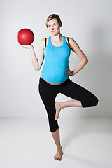 Image showing Pregnant woman exercising with exercise ball while balancing