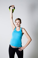 Image showing Pregnant woman exercising with kettlebell
