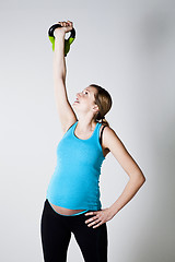 Image showing Pregnant woman exercising with kettlebell