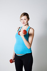 Image showing Pregnant woman exercising with dumbbells