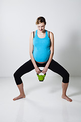 Image showing Pregnant woman exercising with kettlebell