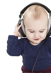 Image showing young child with ear-phones listening to music