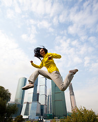 Image showing brunette in a yellow blazer jumping