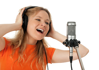 Image showing Young woman in orange t-shirt singing with the microphone