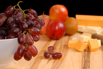 Image showing Wide view of fruit and cheese on cutting board