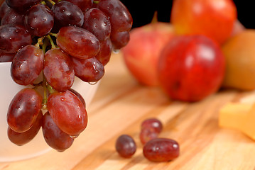 Image showing Close up view of delicious fruit and cheese on cutting board