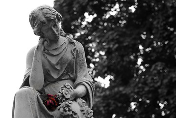 Image showing Granite statue of woman holding a red rose at gravesite
