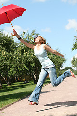 Image showing smiling girl jumping with red umbrella