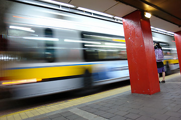 Image showing Bus leaving depot female waiting