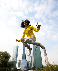 Image showing girl in a yellow blazer jumping