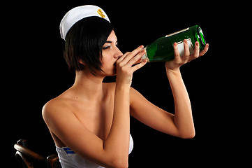 Image showing Young beautiful sailor woman with bottle