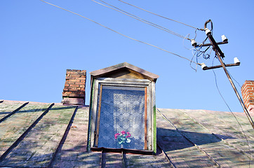 Image showing Ancient rural house tin roof attic window chimneys 