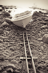 Image showing Fishing boat on stony to seacoast